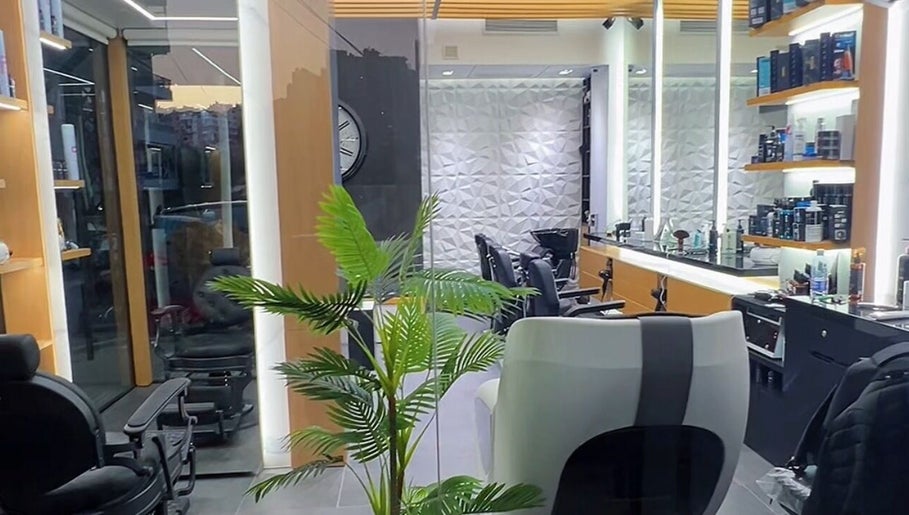 Modern interior of Tahan Barbershop in Beirut, Beirut Governorate, LB showcasing sleek chairs and elegant decor.
