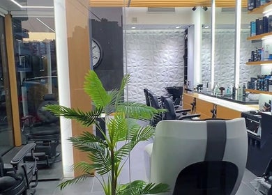 Modern interior of Tahan Barbershop in Beirut, Beirut Governorate, LB showcasing sleek chairs and elegant decor.