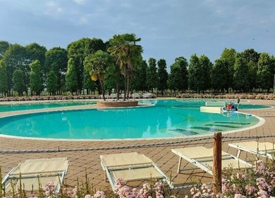 Piscina rilassante a Realign - Elia Freschi, Sesto, Lombardia, IT, circondata da lettini e alberi verdi.