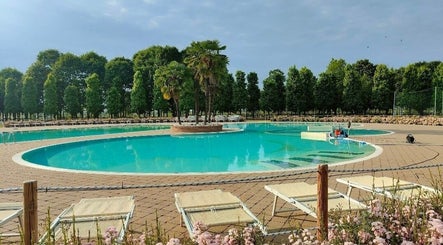 Piscina rilassante a Realign - Elia Freschi, Sesto, Lombardia, IT, circondata da lettini e alberi verdi.