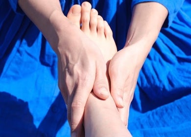 Hand providing a foot massage at Kea Forest, Korora, New South Wales, AU for relaxation.