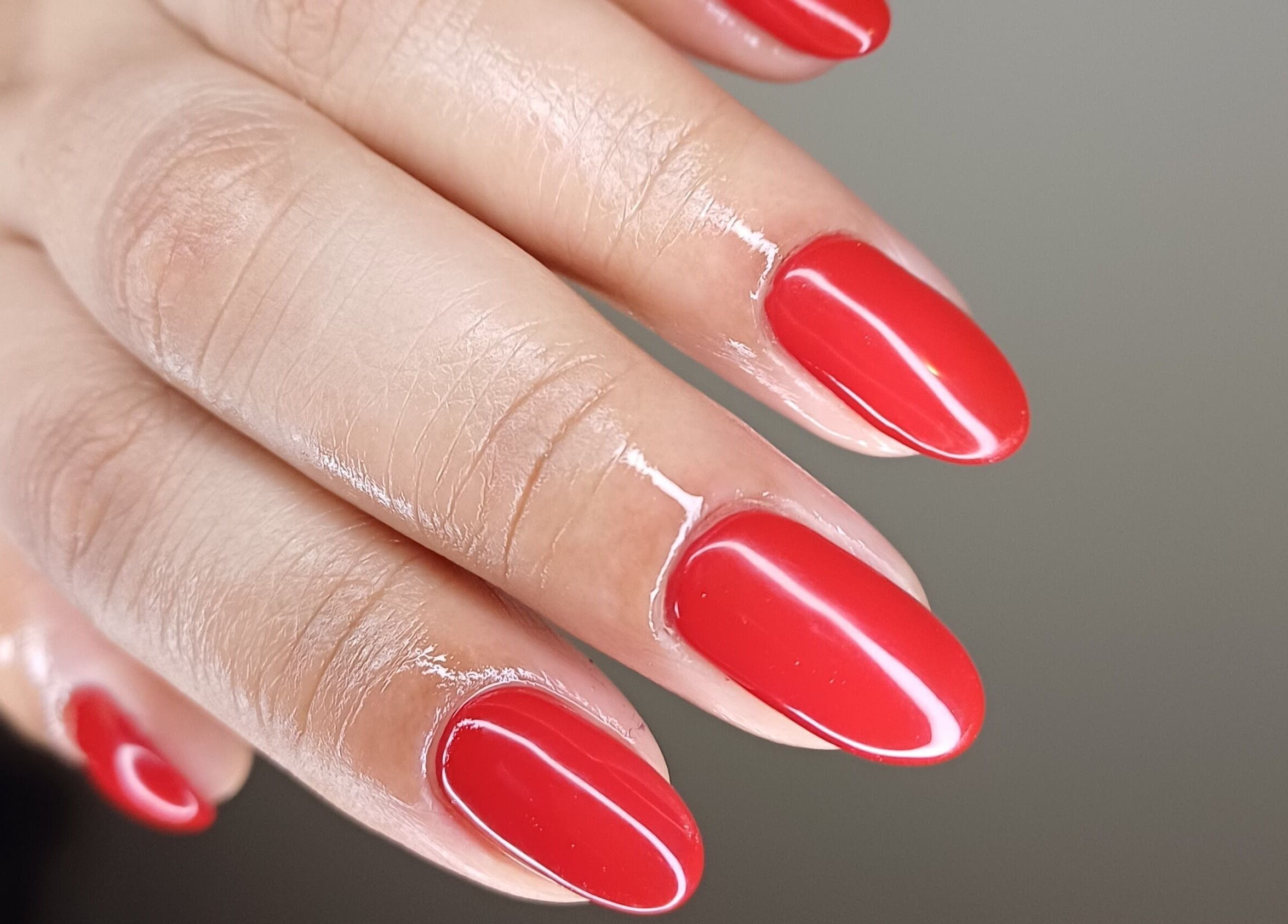 Vibrant red manicure at Tee&Co., Cape Town, Western Cape, ZA, showcasing sleek, glossy finish.