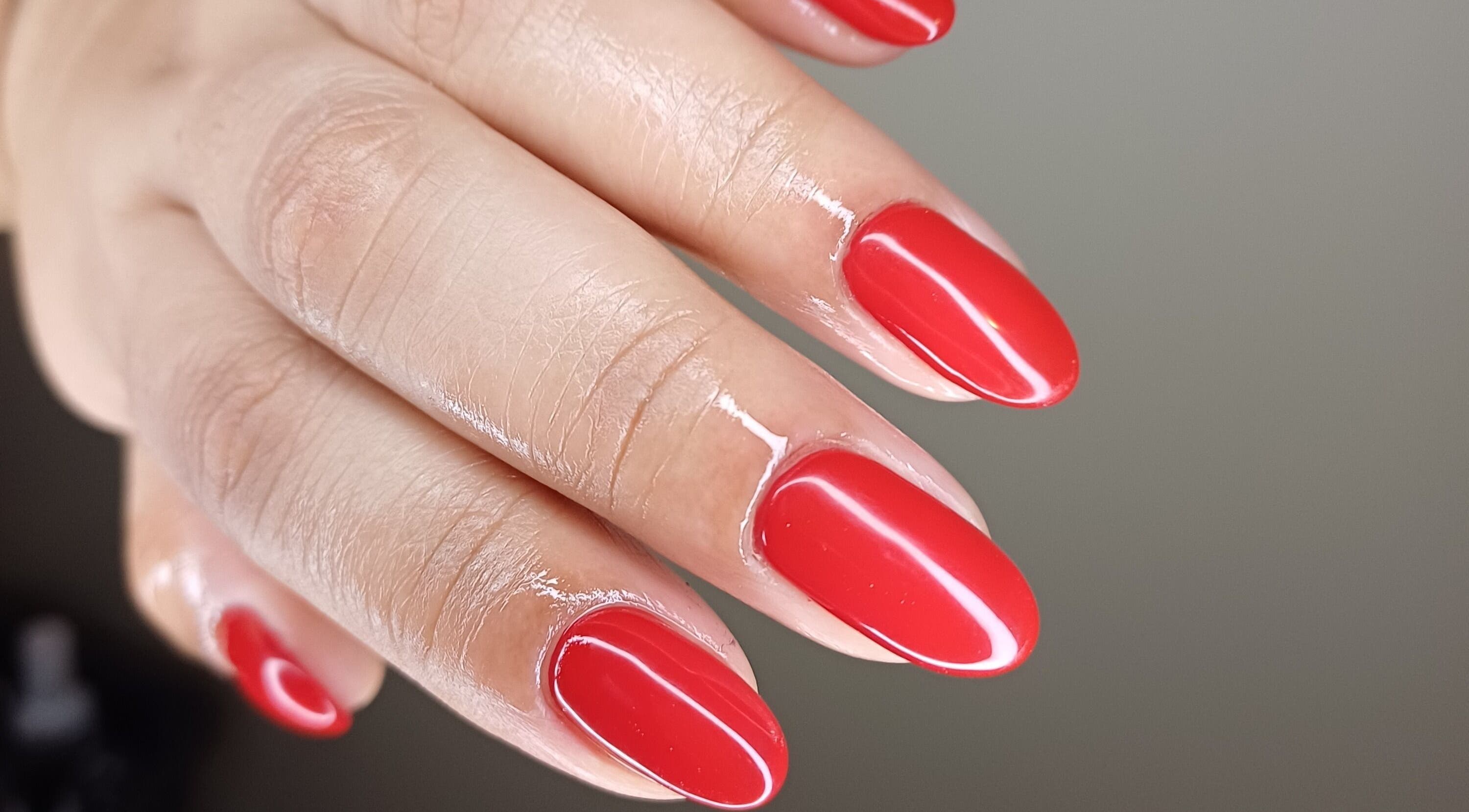 Vibrant red manicure at Tee&Co., Cape Town, Western Cape, ZA, showcasing sleek, glossy finish.
