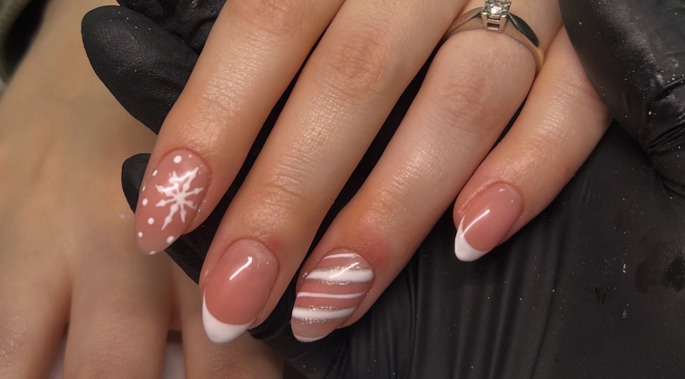 Elegant winter-themed nail art at N0.16beauty in Risca, Wales, GB, with snowflake and white stripes.