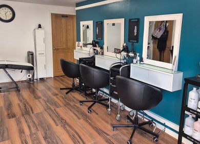 Modern styling chairs and mirrors at Hair Flair, Sheffield, England, GB with wooden flooring.