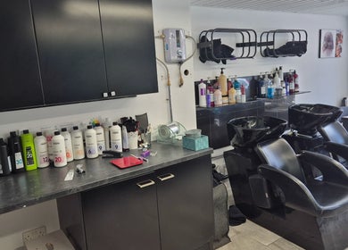 Modern wash area at Hair Flair, Sheffield, England, GB with sleek chairs and shelves of hair products.