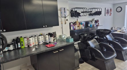 Modern wash area at Hair Flair, Sheffield, England, GB with sleek chairs and shelves of hair products.