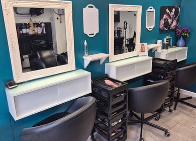 Chic styling stations at Hair Flair, Sheffield, England, GB, featuring elegant mirrors and modern chairs.