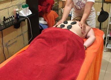 Hot stone massage at Divine Therapy by Katarína in Ix-xagħra, MT offering relaxation and rejuvenation.