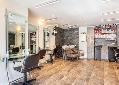 Modern styling area at Valencia Salon, Newcastle upon Tyne, England, GB with sleek chairs and ample products.