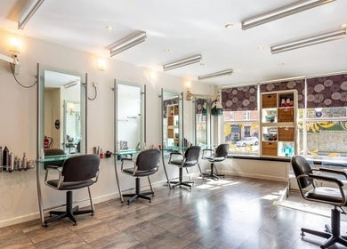 Bright and modern interior of Valencia Salon in Newcastle upon Tyne, England, GB with stylish chairs and mirrors.