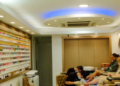 Clients enjoying pedicures at USA STAR NAILS CLAPHAM SOUTH, London, England, GB, showcasing a vast nail polish wall.