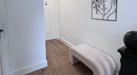 Zehra Zem Aesthetics hallway in London, England, GB showcasing minimalist decor with bench and abstract art.