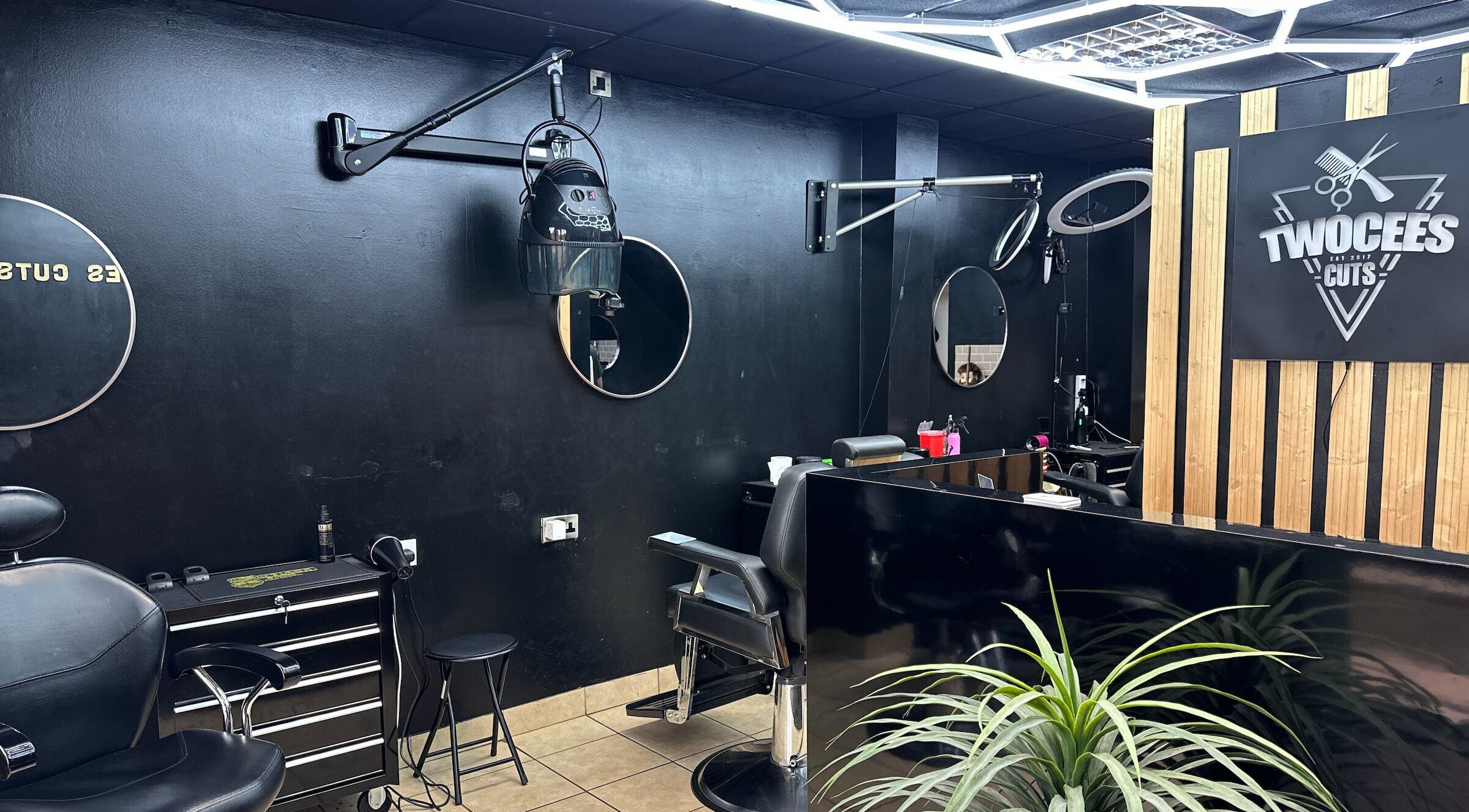 Modern salon interior at Twocees Cuts, Stoke-on-Trent, England, GB showcasing styling stations and mirrors.
