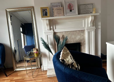 Chic interior at Twocees Cuts in Stoke-on-Trent, England with elegant seating and decor by a fireplace.