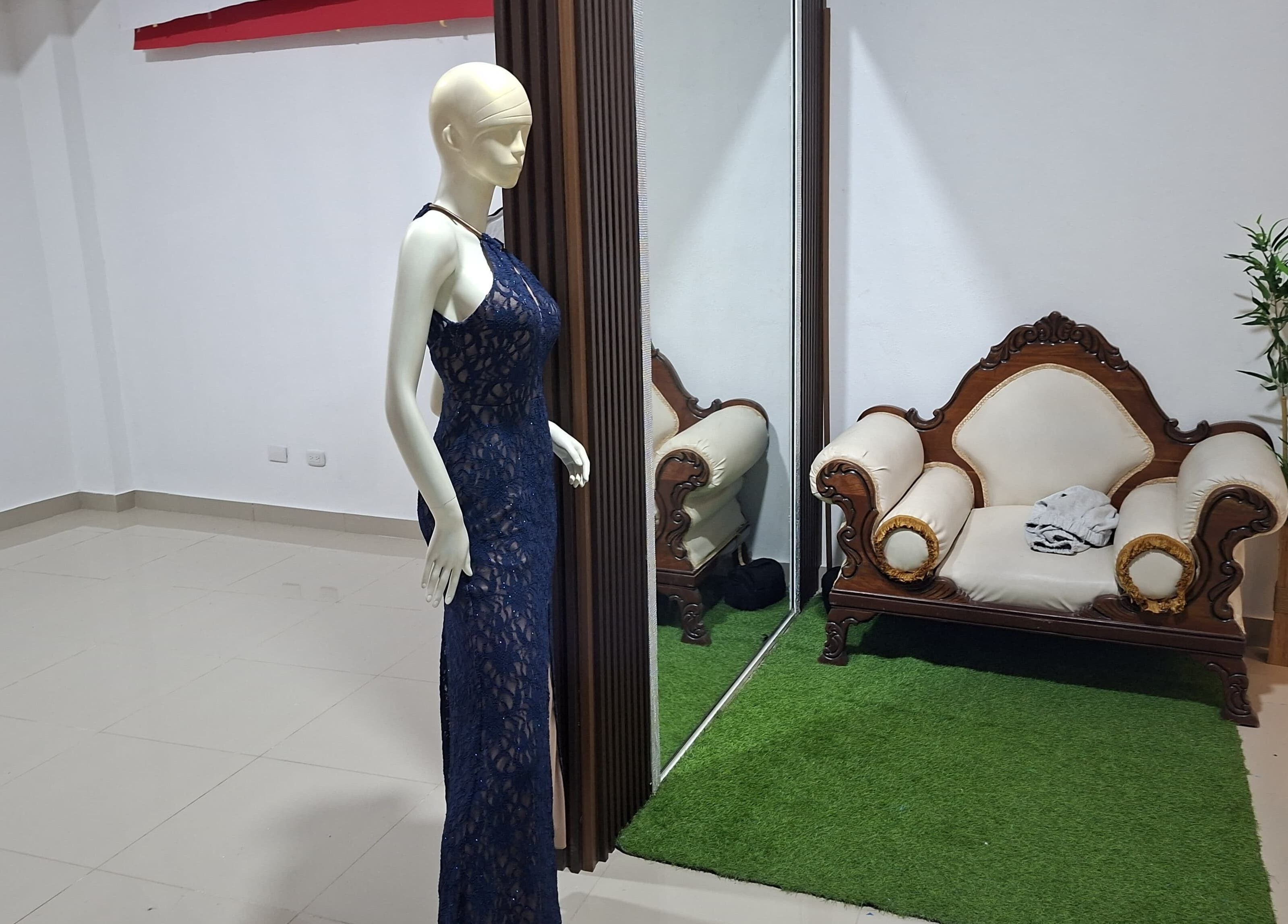 Maniquí con vestido azul en LAFOTOFILM, Santo Domingo, Santo Domingo, DO, junto a sofá antiguo y planta decorativa.