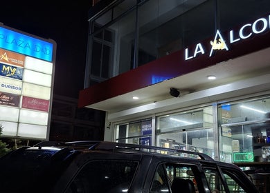 Vista nocturna de Plaza D&D con múltiples tiendas en Santo Domingo, destacando LAFOTOFILM.