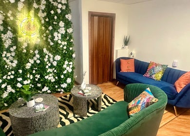 Cozy seating area with vibrant couches and floral wall at Cynergi Healing Center, Worcester, Massachusetts, US.