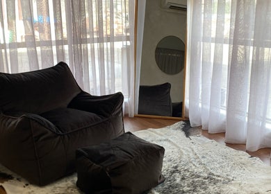 Relaxing corner at The Nail Station, Porepunkah, Victoria, AU featuring plush seating and soft drapes.