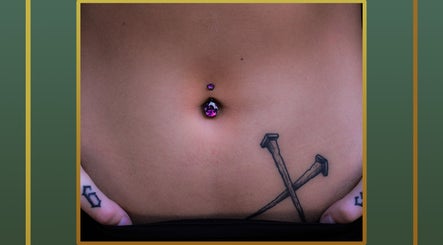 Close-up of a purple navel piercing at Gilded Touch Piercings, Glasgow, Scotland, GB, showcasing intricate tattoo art.