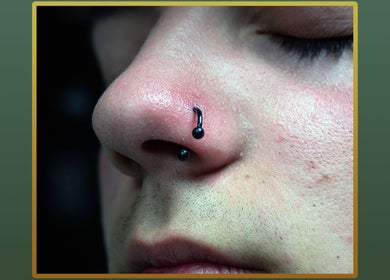 Nose adorned with elegant black ring at Gilded Touch Piercings, Glasgow, Scotland, GB.