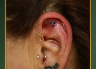 Trio purple gemstones ear piercing at Gilded Touch Piercings, Glasgow, Scotland, GB showcasing unique style.