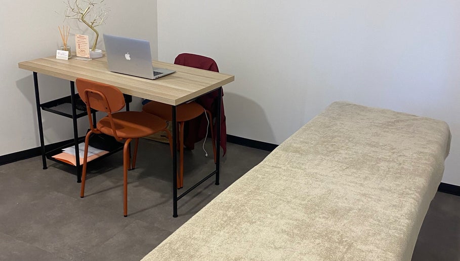 Salle de bien-être chez Mélinka M, Noisy-le-grand, Île-de-France avec bureau et table de soins.