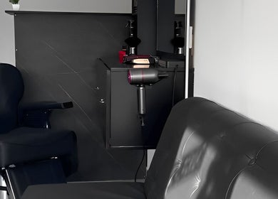 Interior moderno y elegante de Quimera Barbershop en Tepic, Nayarit, MX, con silla de barbero y espejo.