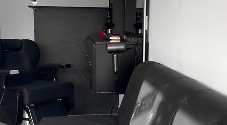 Interior moderno y elegante de Quimera Barbershop en Tepic, Nayarit, MX, con silla de barbero y espejo.