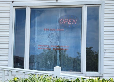 Front view of Your Beauty Bazaar Salon & Spa in Rochester, New York, US with an open sign on the window.