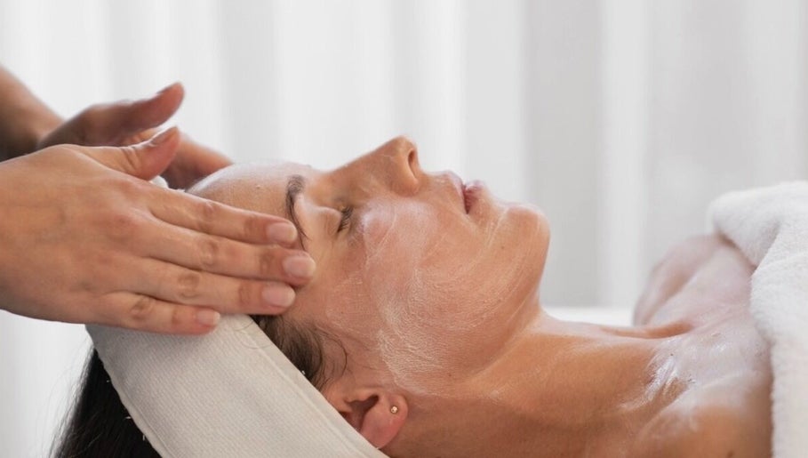 Facial treatment at Soul Body & Beauty, Port Fairy, Victoria, AU. Hands apply cream to relaxed client.