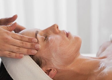 Facial treatment at Soul Body & Beauty, Port Fairy, Victoria, AU. Hands apply cream to relaxed client.