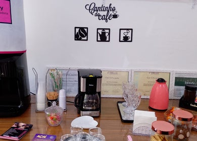 Cantinho do café em Maiza Beauty - São Caetano do Sul com cafeteira e certificados na parede. São Caetano Do Sul, São Paulo, BR.