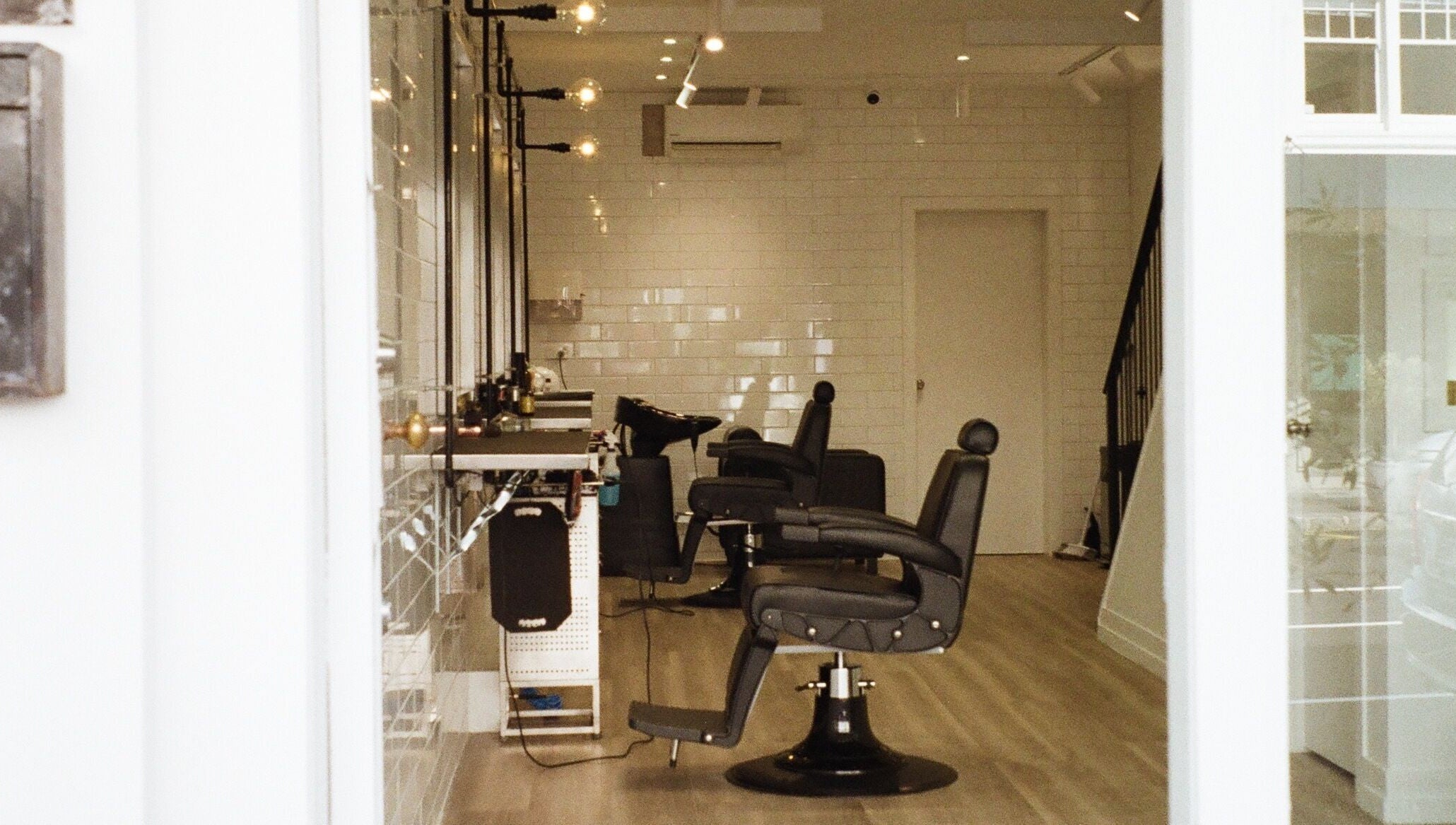 Modern interior of Tokoya Barber and Salon in Auckland, Auckland, NZ, featuring sleek black chairs.