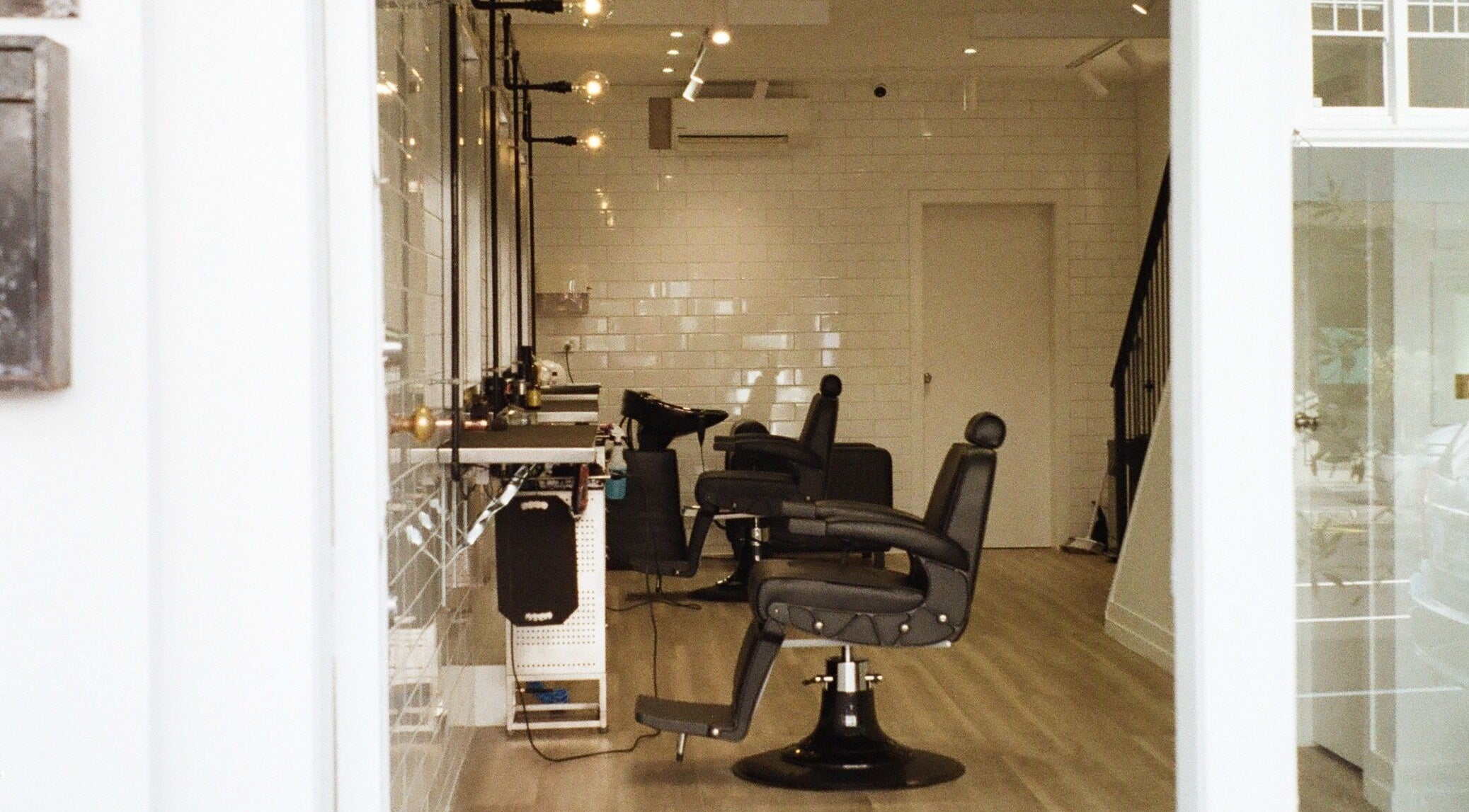 Modern interior of Tokoya Barber and Salon in Auckland, Auckland, NZ, featuring sleek black chairs.