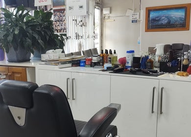Cozy interior of DOAN BARBER $20 in Heidelberg West, Victoria, AU, showcasing styling tools and comfy chairs.
