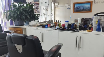 Cozy interior of DOAN BARBER $20 in Heidelberg West, Victoria, AU, showcasing styling tools and comfy chairs.