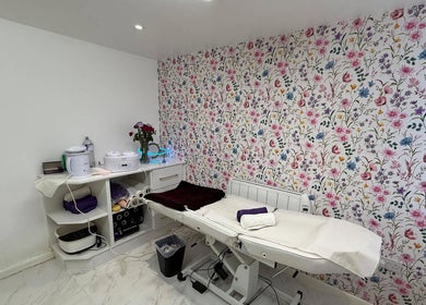 Cozy treatment room with floral wallpaper at Glow Beauty Salon, Maidenhead, England, GB.