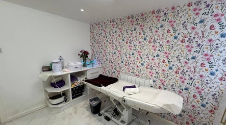 Cozy treatment room with floral wallpaper at Glow Beauty Salon, Maidenhead, England, GB.