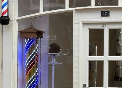 Entrance of Glow Beauty Salon with vintage barber pole in Maidenhead, England, GB.