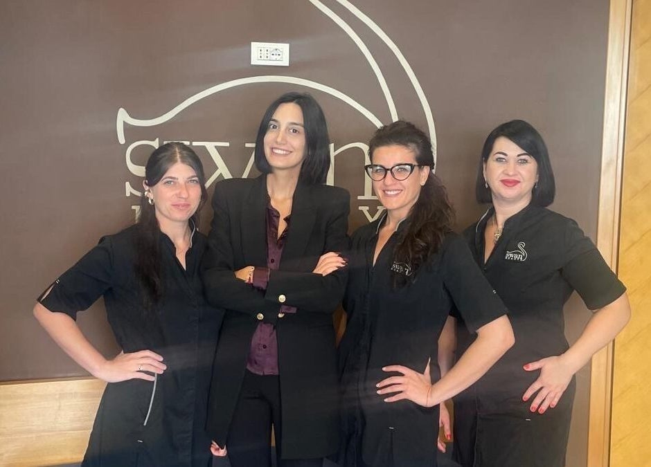 Staff di Swan Beauty Appia a Roma, Lazio, IT, sorridenti davanti al logo del centro.