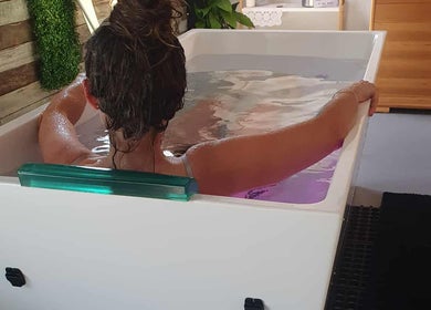 Relaxing woman in a soothing bath at The Grounding Room Sauna, Chatsworth, Queensland, AU.