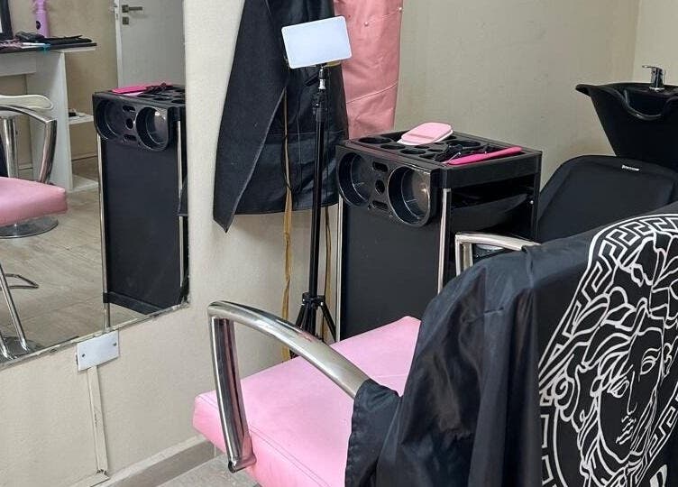 Silla rosa elegante en El Salon De Pelo, Córdoba, AR con tocador y fregadero moderno.