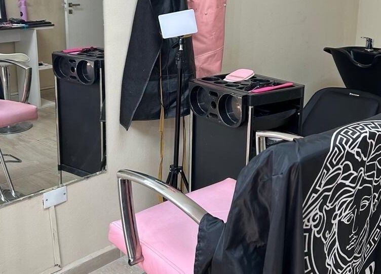 Silla rosa elegante en El Salon De Pelo, Córdoba, AR con tocador y fregadero moderno.