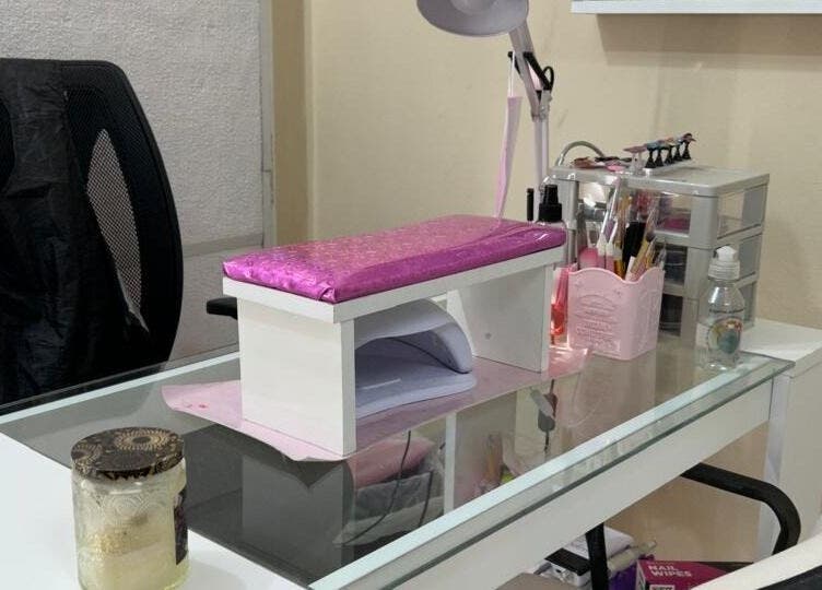 Mesa de manicura en El Salon De Pelo, Córdoba, Córdoba, AR, con lámpara y herramientas de belleza.
