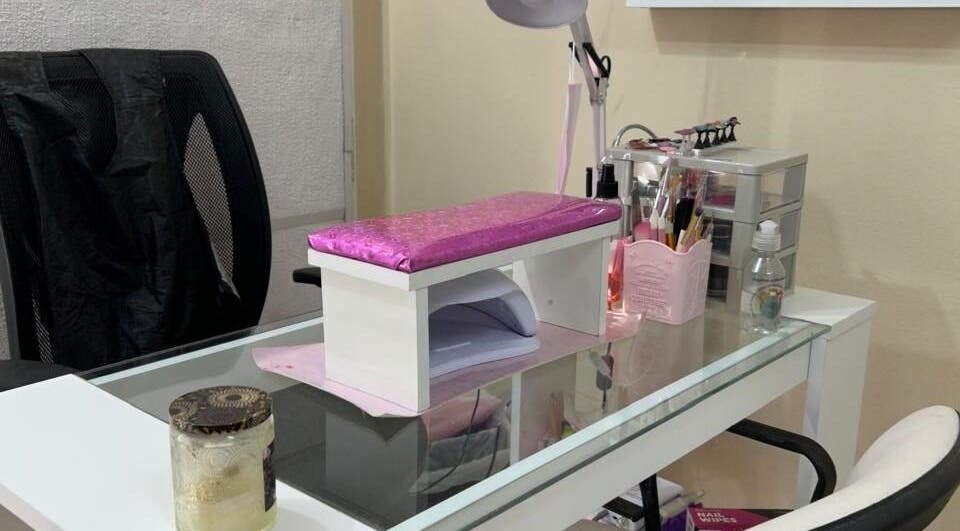 Mesa de manicura en El Salon De Pelo, Córdoba, Córdoba, AR, con lámpara y herramientas de belleza.