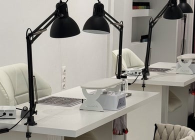 Modern nail stations at Adela nail studio in Thessaloniki, GR, featuring sleek white tables and elegant chairs.