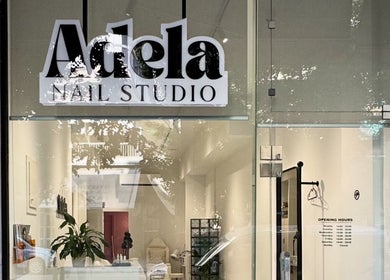 Front view of Adela nail studio in Thessaloniki, GR, showcasing modern glass entrance.