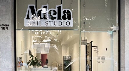Front view of Adela nail studio in Thessaloniki, GR, showcasing modern glass entrance.