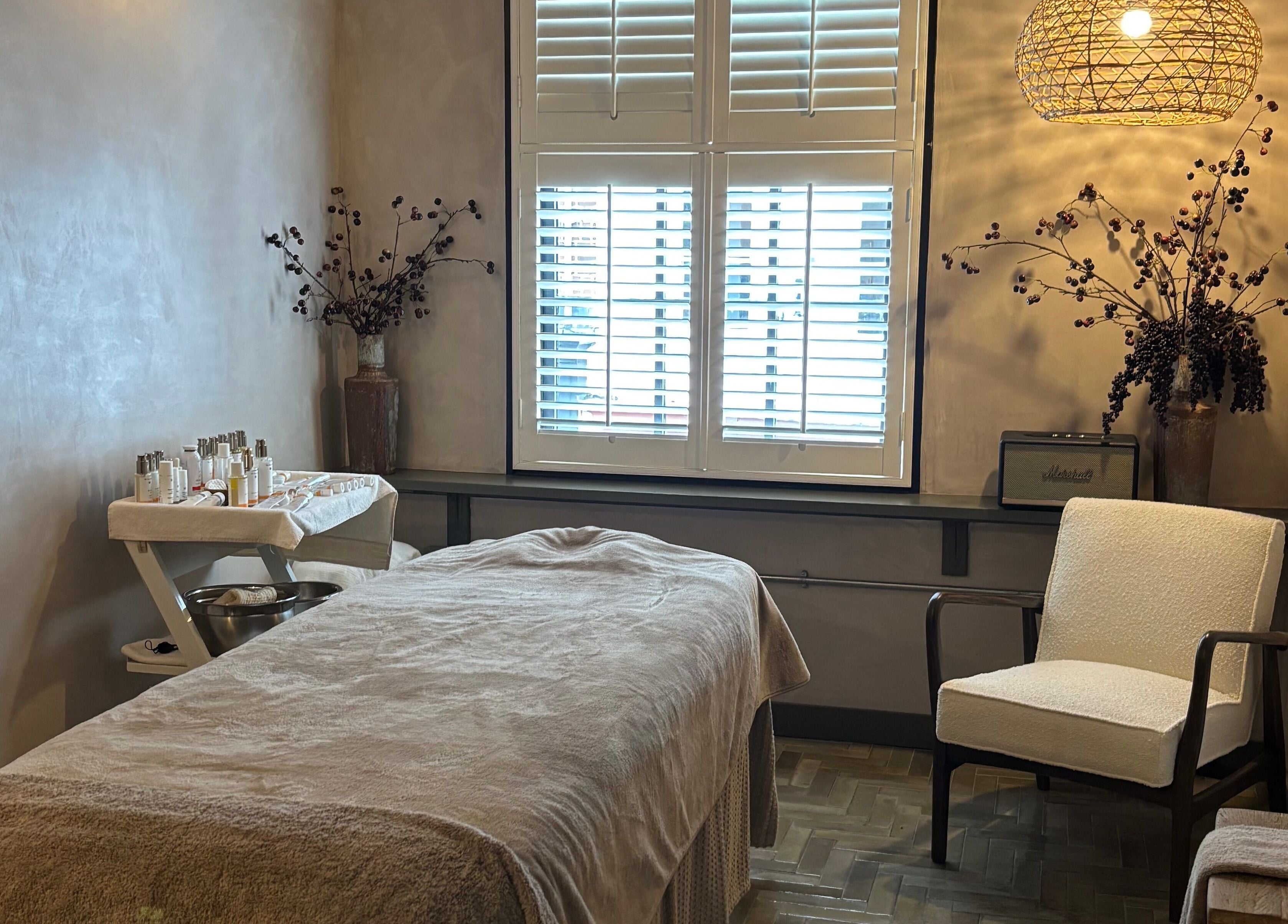 Cozy treatment room at Elaine Sadler Skin Health, Warwick, England, GB, featuring a comfortable bed and ambient decor.